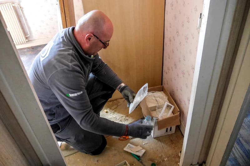 Technicien vérifiant un dispositif anti-termites dans une maison