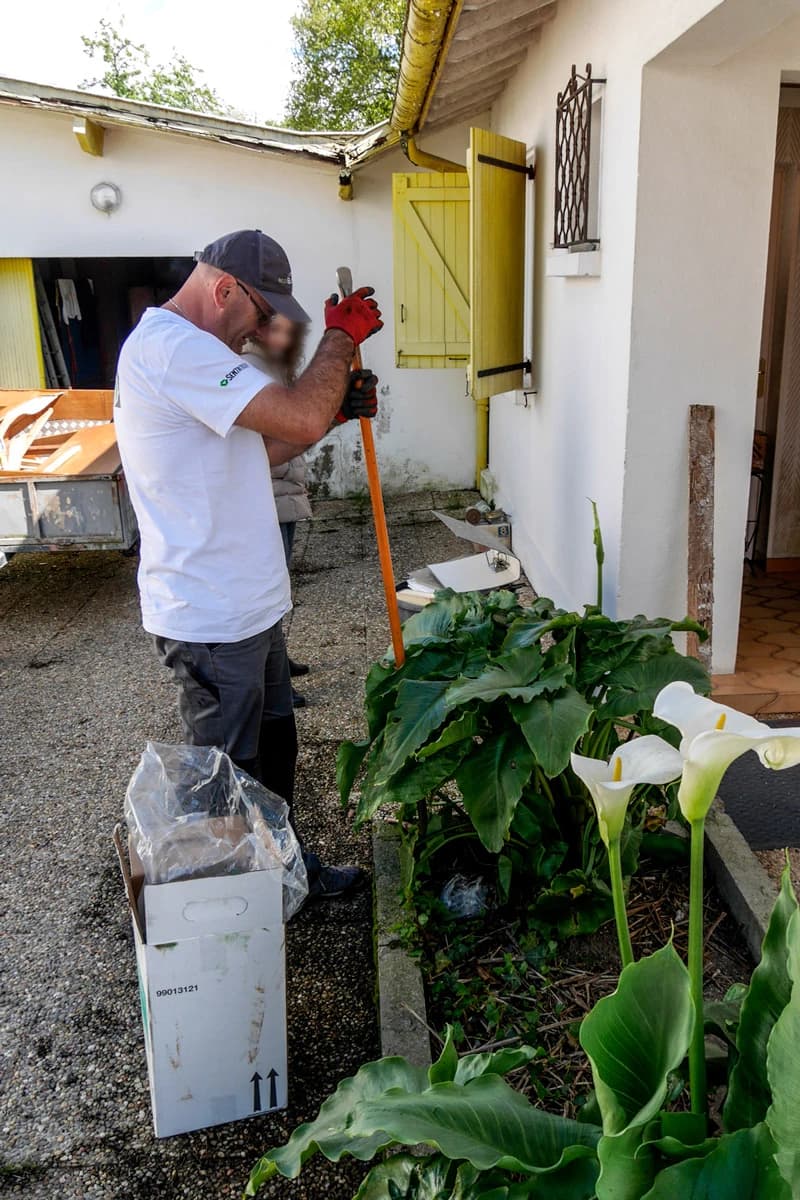 Technicien préparant la pose de pièges anti-termites autour d’une maison